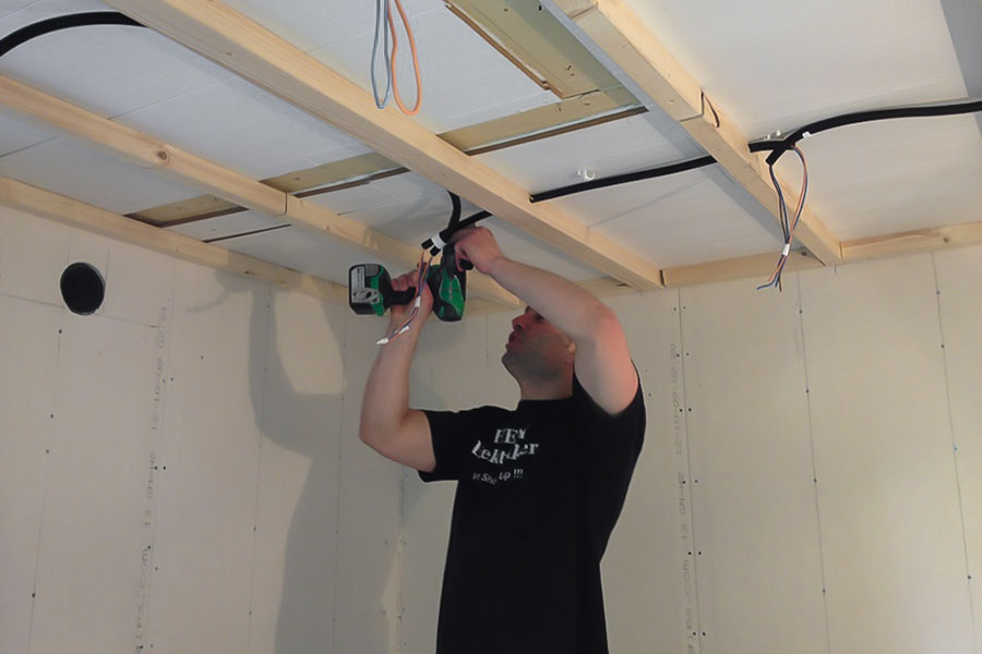 Elektriker monterar elkabel i tak